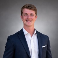 Luke M. Dispain wearing a navy jacket and white shirt
